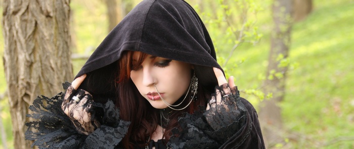 Gothic woman with piercings in a forest