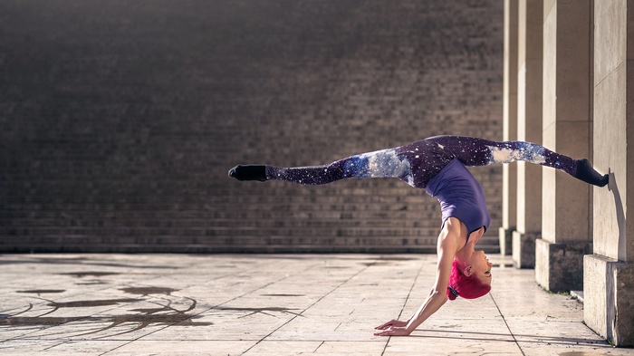 Woman performing a handstand with legs split