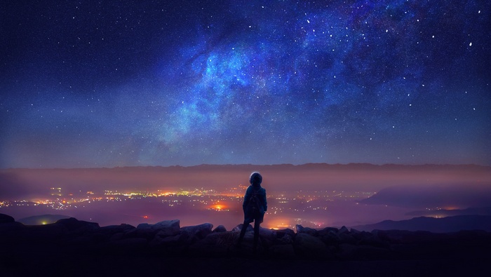 Person looking at the starry night sky over a city
