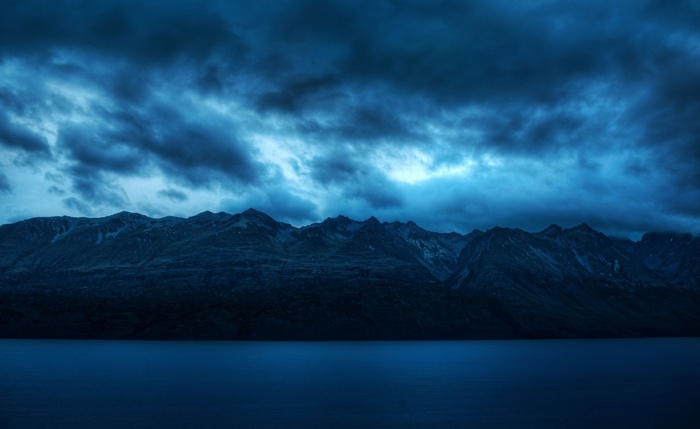 Dark clouds over mountains and a lake