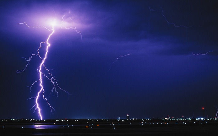 Lightning strikes over an airport at night