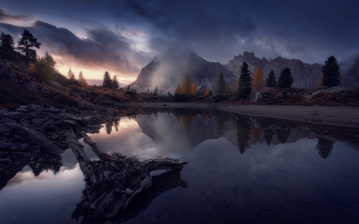 Lake reflection of mountains and trees in Italy during fall