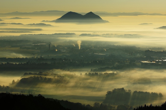 Misty valley with factories and mountains in Slovenia