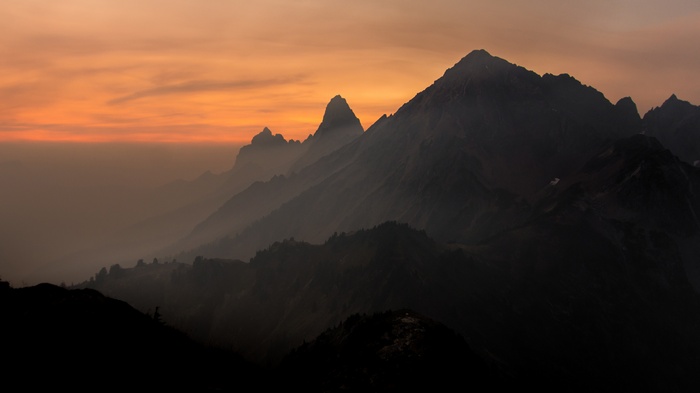 Mountains shrouded in mist during sunset