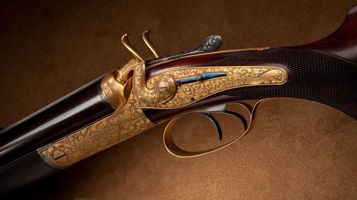 Engraved shotgun with gold and blue accents