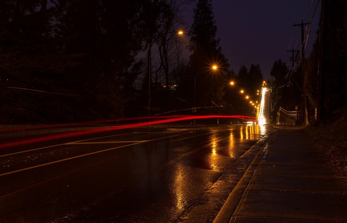 Long exposure of a wet road at night with light trails