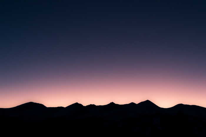 Silhouette of mountains against a twilight sky