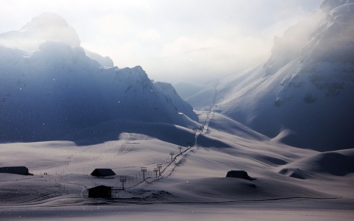 Snowy mountains with ski lifts and houses