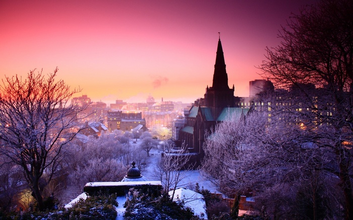 Winter sunrise over a snowy city with a church
