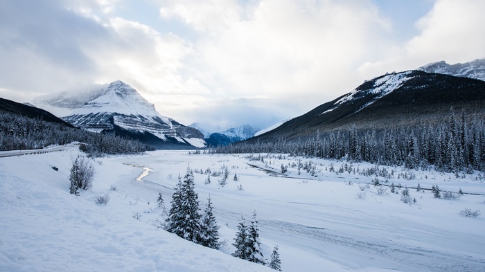 Snowy mountains and forest with a winding river