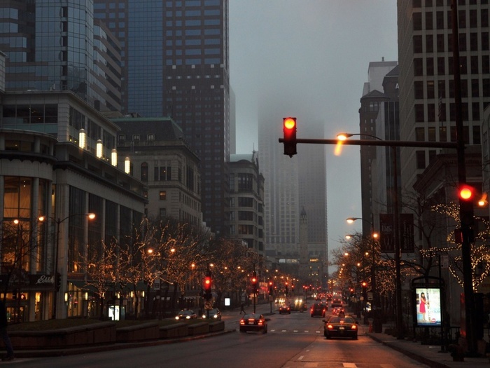 City street with traffic lights and Christmas lights in mist