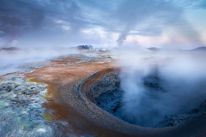 Geothermal landscape in Iceland with steam and cracked earth