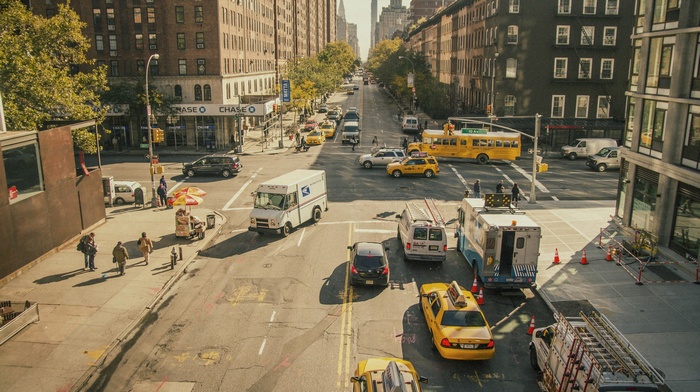 New York City street with yellow cabs and a school bus