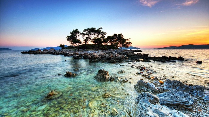 Island with trees and rocks at sunset