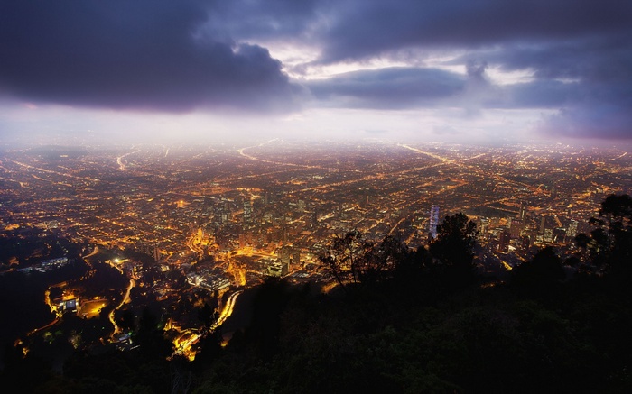 Cityscape at night with lights and clouds