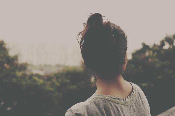 Woman with hair bun looking out at nature