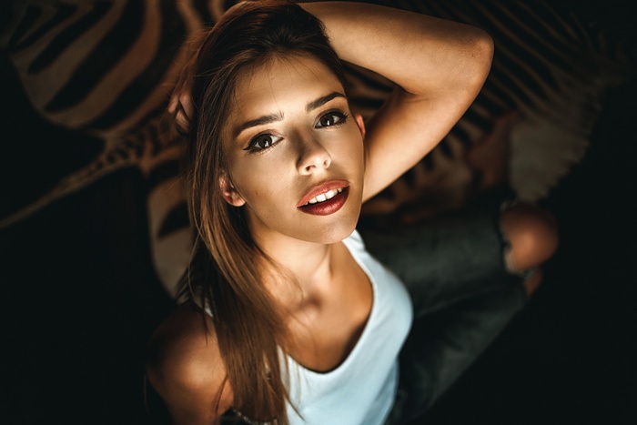 Model with arms up, wearing a white tank top