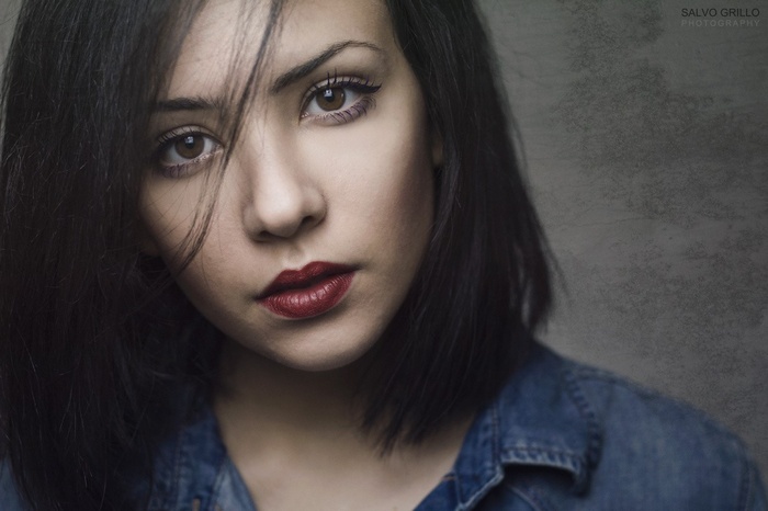 Portrait of a woman with dark hair and red lipstick
