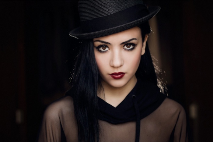 Woman in a black hat and sheer top