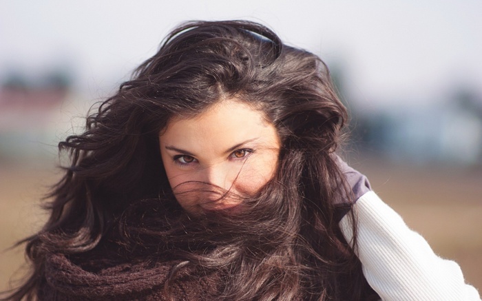 Woman with dark hair blowing in the wind