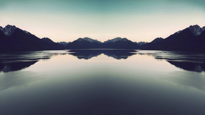Mirror image of mountains reflected in a calm lake