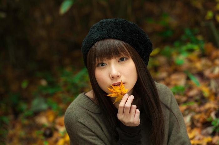 Asian woman in black hat holding a leaf