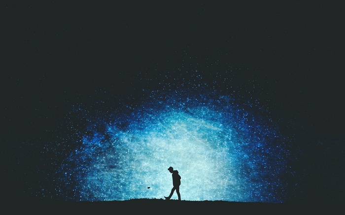Silhouette of a person walking under a starry sky