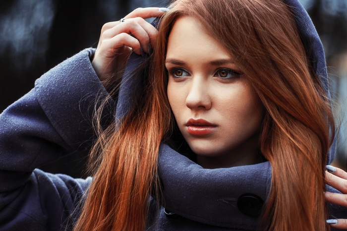 Woman with red hair wearing a blue coat