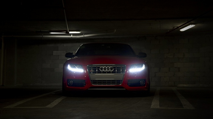 Red Audi car parked in a dark garage