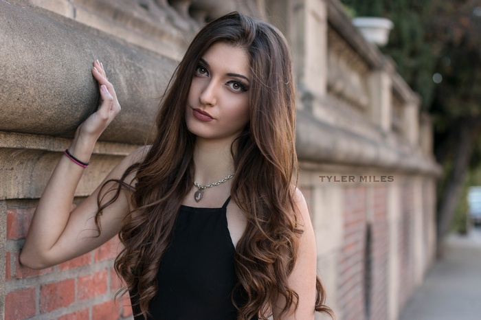 Woman leaning on a stone wall