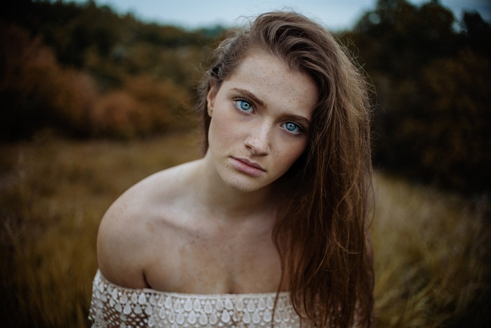 Woman with blue eyes and freckles in a field