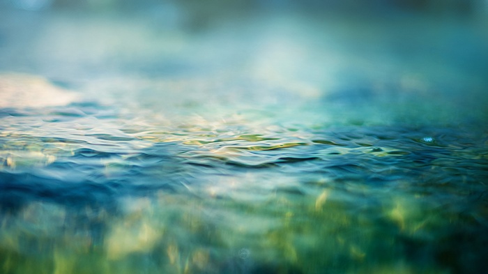 Close-up photography of rippling water with green and blue hues