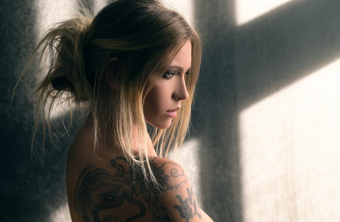 Woman with tattoos looking away from the camera
