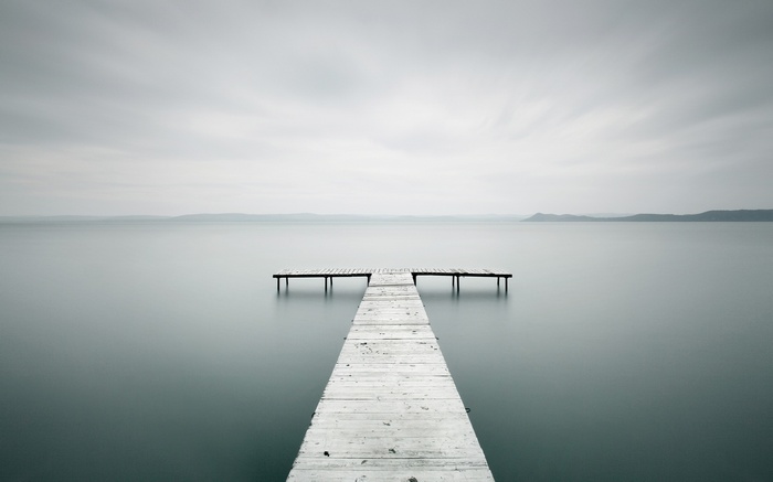Long exposure photography of a wooden pier on a calm lake