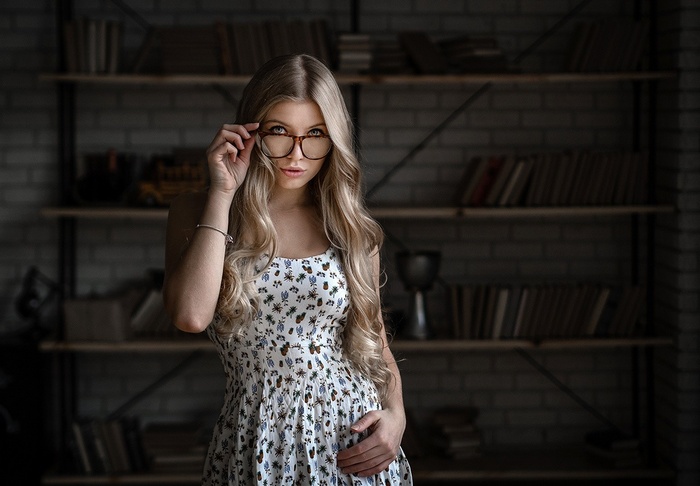 Woman with blonde hair wearing glasses and a dress