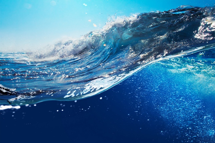 Underwater wave with bubbles and sunlight