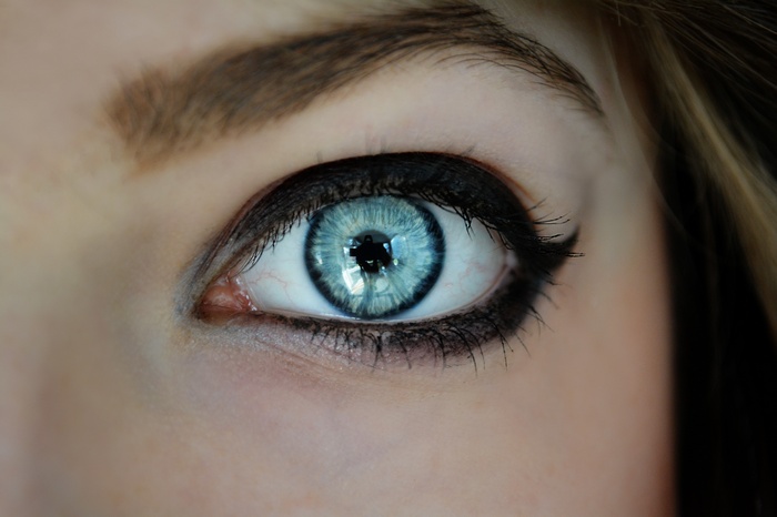 Close-up of a woman's blue eye with reflection