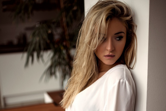 Blonde woman in white shirt looking away