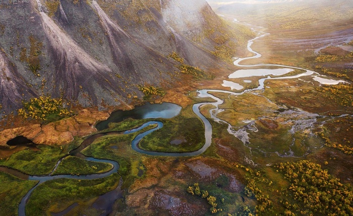 Aerial view of a winding river in a mountainous landscape in Sweden