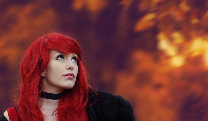 Redhead woman with bright red hair looking up