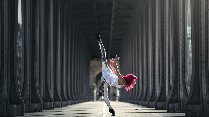 Woman with dyed hair performing a dance split