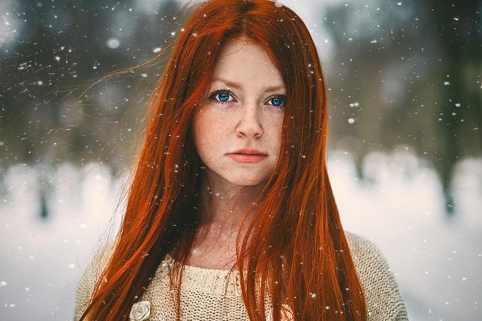 Redhead woman with blue eyes in the snow