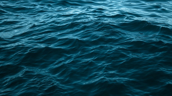 Deep blue ocean waves with light reflections