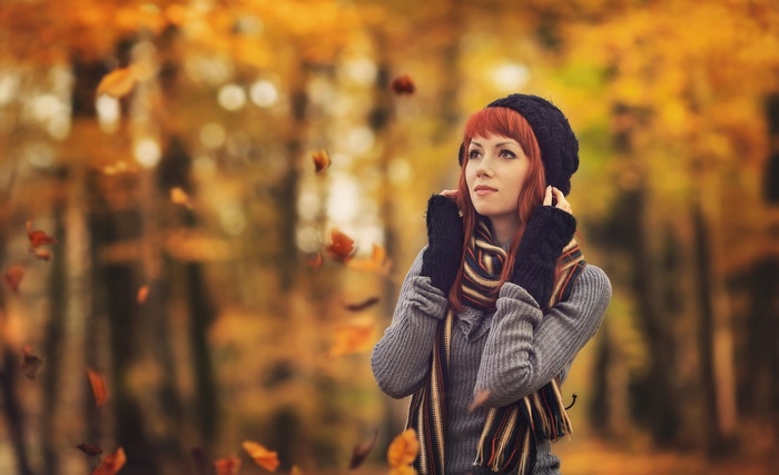 Woman in autumn park with falling leaves