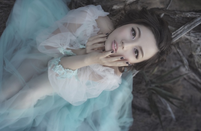Asian woman in a flowing gown lying down