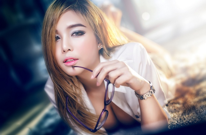 Asian woman with glasses lying down