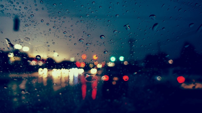 Rainy street lights seen through a wet window
