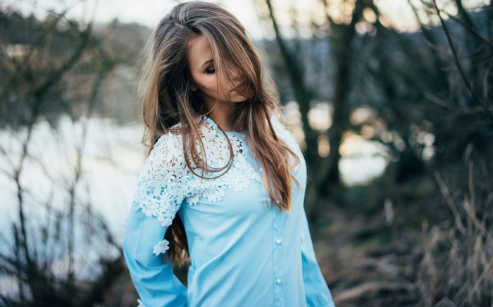 Woman in a blue shirt with lace details outdoors