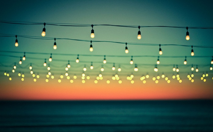 String lights over the sea at dusk