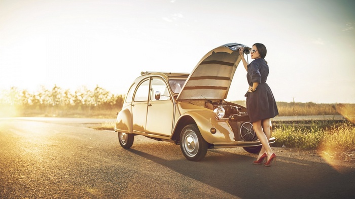Woman with classic Citroën 2CV car on a road